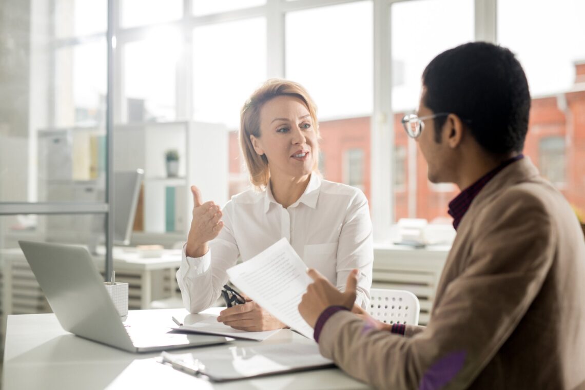 Manager and staff member having a calm workplace conversation, representing practical leadership, staff wellbeing and psychological safety training