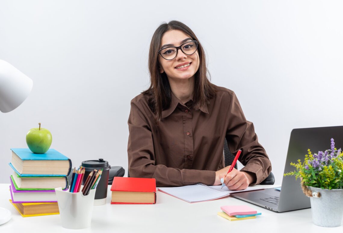 Teacher writing at a desk, representing school wellbeing sessions and student support training in Australia.